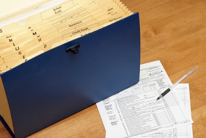 A folder of records and a tax form on the table.