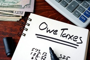 Notepad with sign Owe Taxes