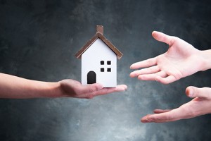 Person being handed a house
