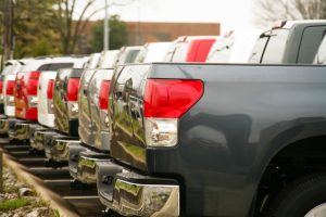 A row of shiny new trucks parked at a car dealership.