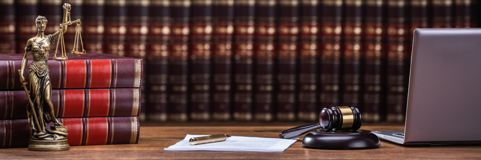 Closeup Of Mallet And Legal Book With Justice Scale On Table In Courtroom